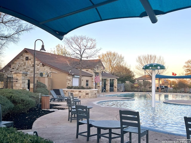 community pool with a patio and fence