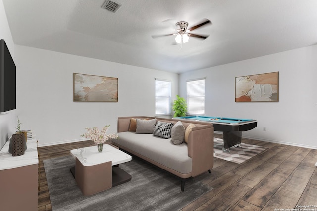 living area featuring visible vents, baseboards, and wood finished floors