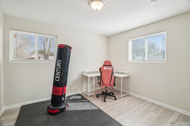 home office with plenty of natural light, baseboards, and wood finished floors