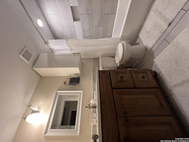 bathroom with visible vents and toilet