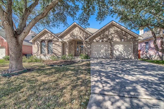 view of front of home featuring a front yard, concrete driveway, brick siding, and an attached garage