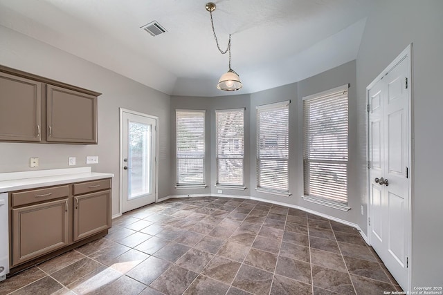 unfurnished dining area featuring vaulted ceiling, visible vents, and baseboards