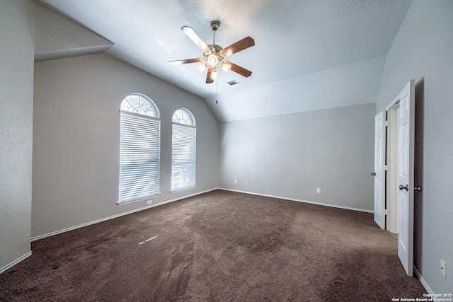 spare room featuring visible vents, baseboards, vaulted ceiling, a ceiling fan, and carpet