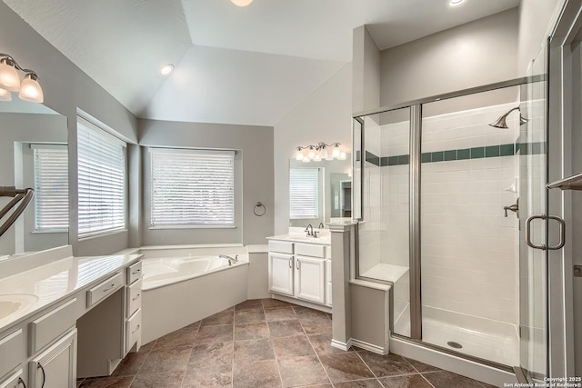 full bathroom featuring two vanities, a garden tub, vaulted ceiling, and a shower stall