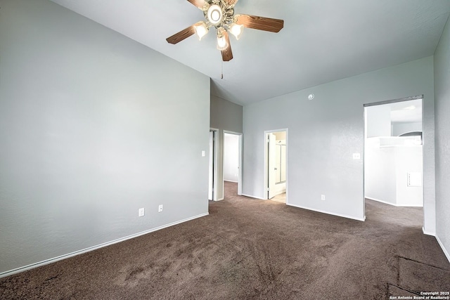 unfurnished bedroom with a walk in closet, carpet flooring, lofted ceiling, and baseboards