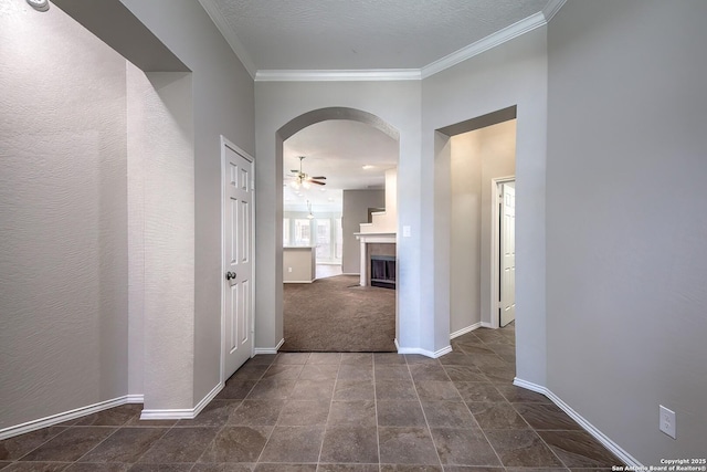 hall featuring arched walkways, ornamental molding, and baseboards