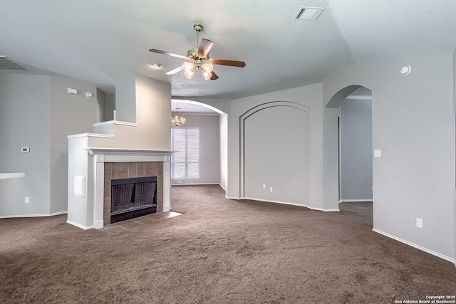 unfurnished living room featuring ceiling fan, a tile fireplace, carpet floors, visible vents, and baseboards