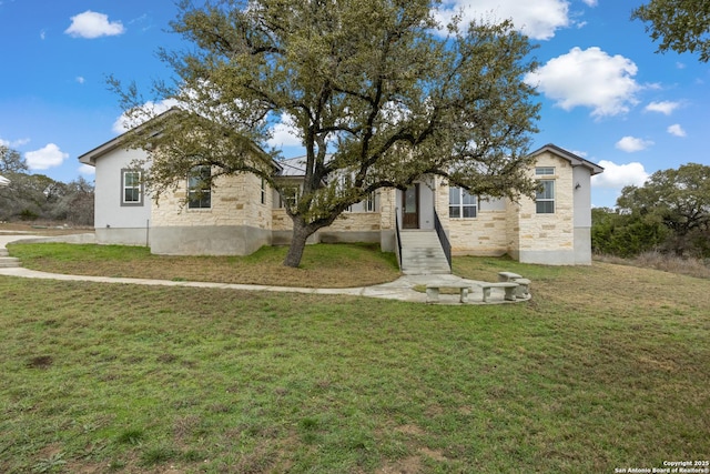 view of front facade with stone siding and a front lawn