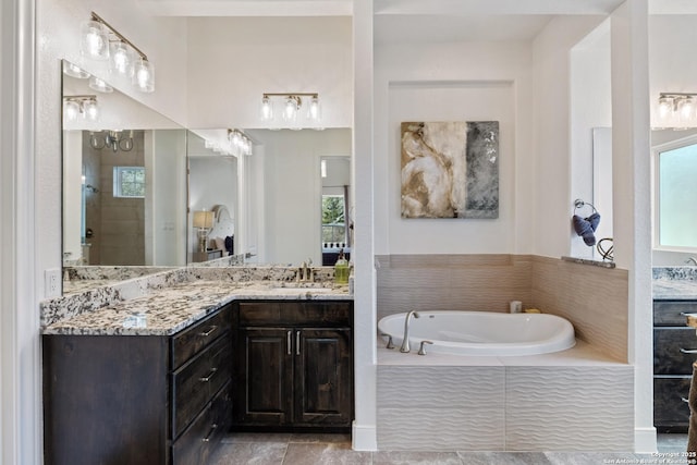 full bath featuring vanity, a garden tub, and a wealth of natural light