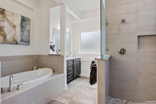 bathroom with walk in shower, a garden tub, and vanity