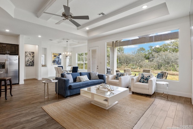 living area featuring a raised ceiling, wood finished floors, and recessed lighting