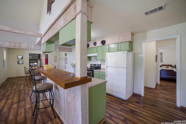 kitchen with visible vents, freestanding refrigerator, a peninsula, stainless steel electric range, and green cabinets
