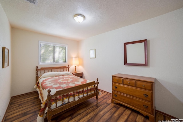 bedroom featuring a textured ceiling and dark wood-style flooring