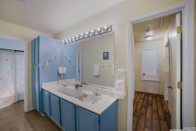 bathroom featuring double vanity, a shower with shower curtain, and a sink