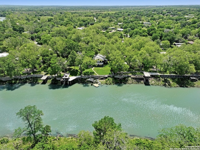 drone / aerial view featuring a water view and a wooded view