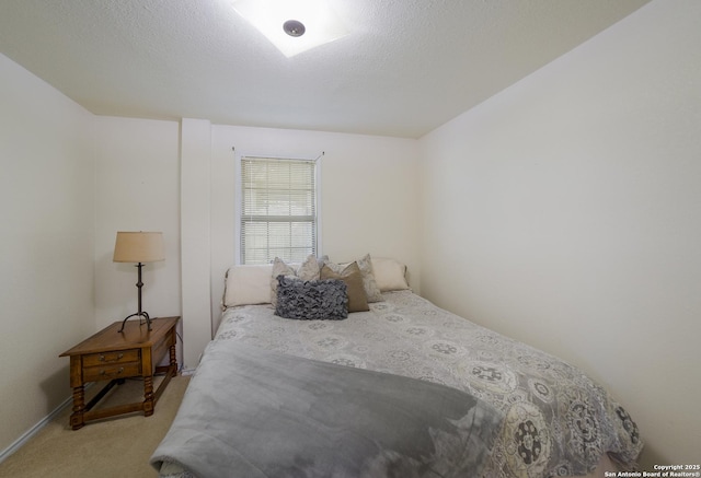 bedroom with light carpet and a textured ceiling