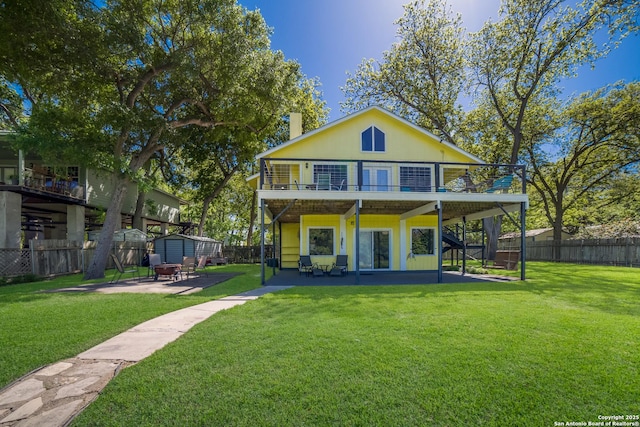 back of house with a patio area, an outdoor structure, a fenced backyard, and a shed