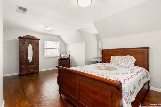 bedroom featuring vaulted ceiling, dark wood-style flooring, visible vents, and baseboards