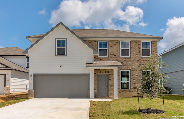 view of front of home featuring a garage, a front lawn, concrete driveway, and brick siding