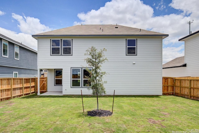 rear view of house featuring a yard, a patio area, and a fenced backyard