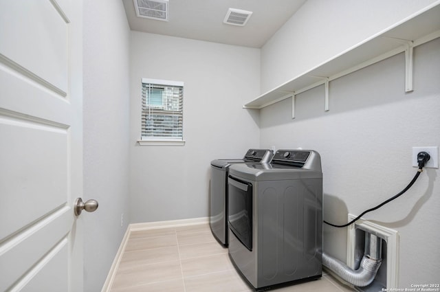 clothes washing area featuring laundry area, baseboards, visible vents, and washing machine and clothes dryer