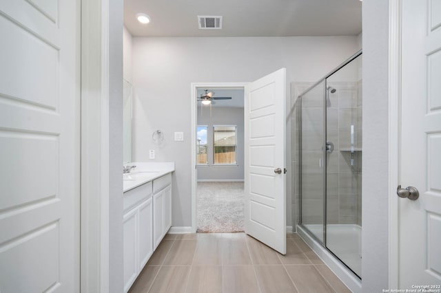 full bath with visible vents, a stall shower, vanity, tile patterned flooring, and baseboards