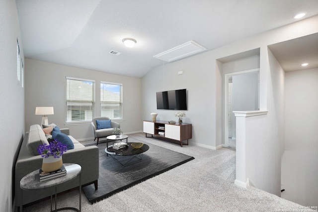 living room with lofted ceiling, visible vents, baseboards, carpet, and attic access