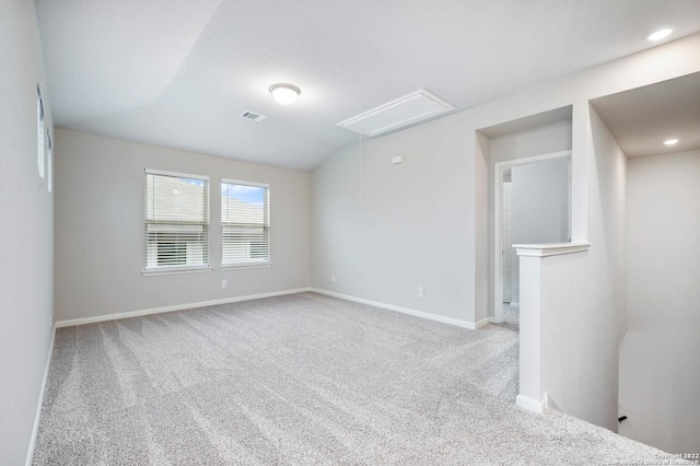 empty room featuring carpet, attic access, visible vents, and baseboards