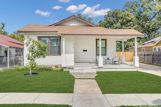 bungalow-style home with a front yard and fence