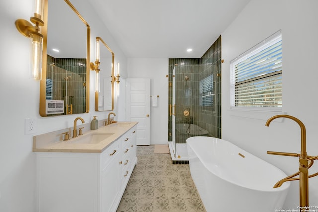 bathroom with double vanity, a stall shower, a freestanding bath, and a sink