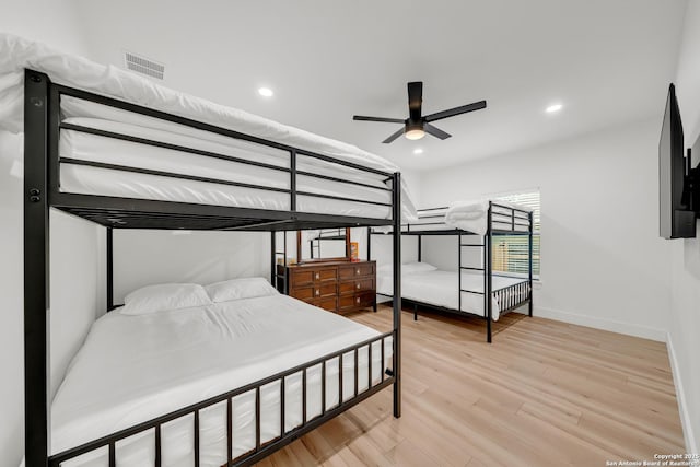 bedroom with baseboards, light wood finished floors, visible vents, and recessed lighting