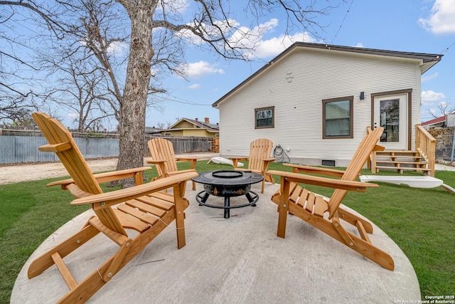 back of house with a fire pit, a yard, and fence