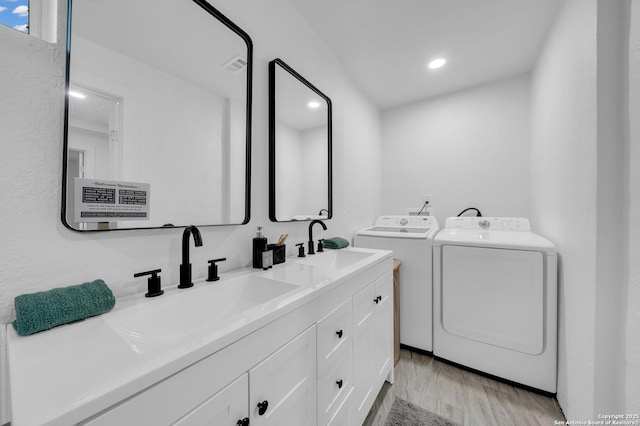 clothes washing area featuring recessed lighting, a sink, separate washer and dryer, light wood-type flooring, and laundry area