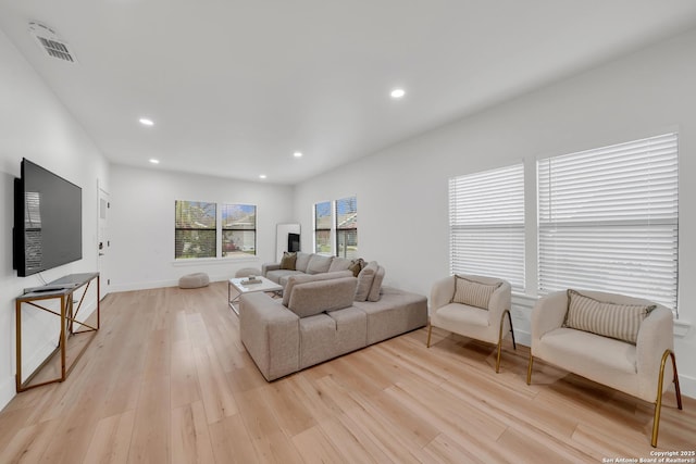 living area with light wood-style floors, baseboards, visible vents, and recessed lighting