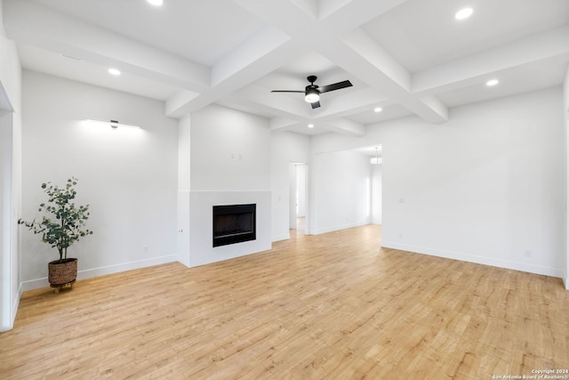 unfurnished living room with light wood finished floors, coffered ceiling, beamed ceiling, a fireplace, and recessed lighting