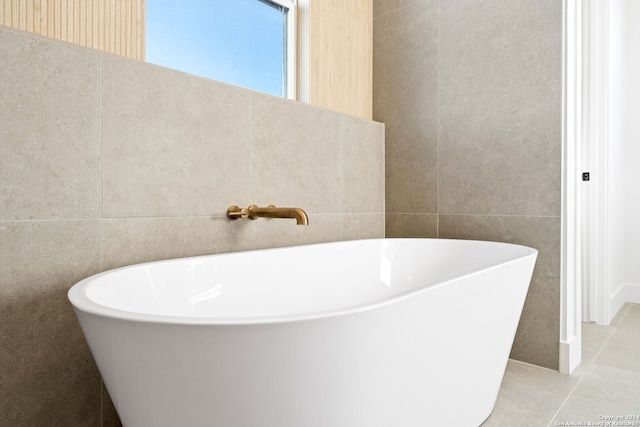 full bath with a soaking tub, tile patterned flooring, and tile walls