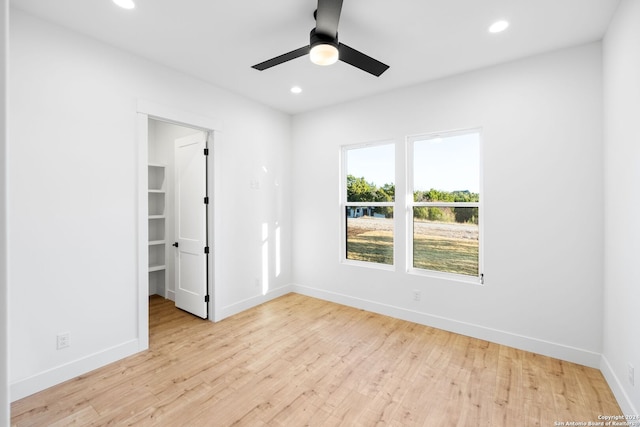 unfurnished bedroom with a spacious closet, wood finished floors, and recessed lighting