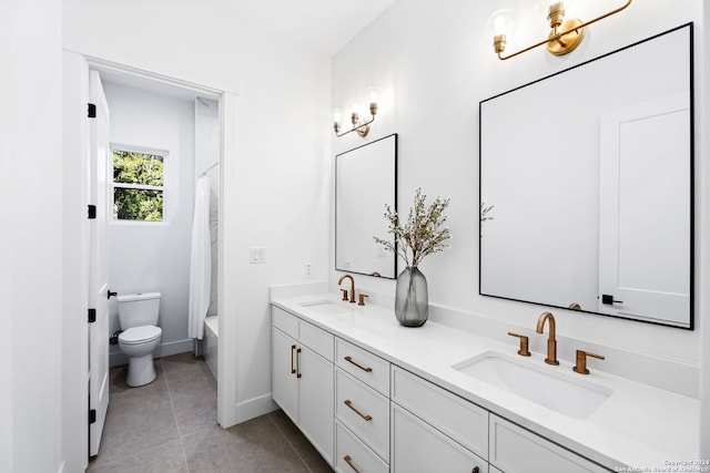 bathroom featuring double vanity, tile patterned flooring, a sink, and toilet