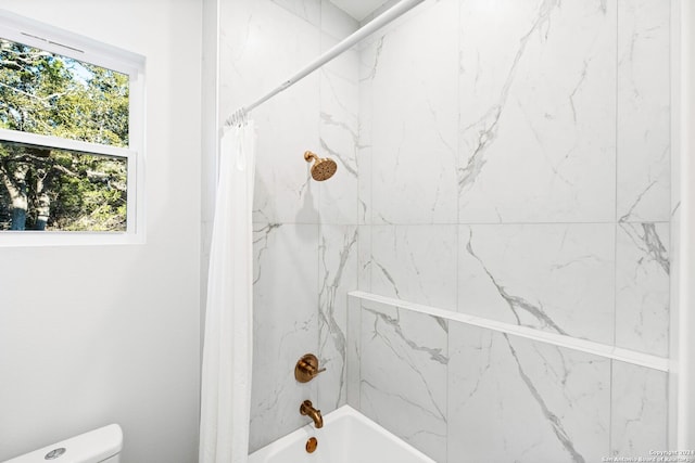 bathroom with shower / bath combination with curtain and toilet