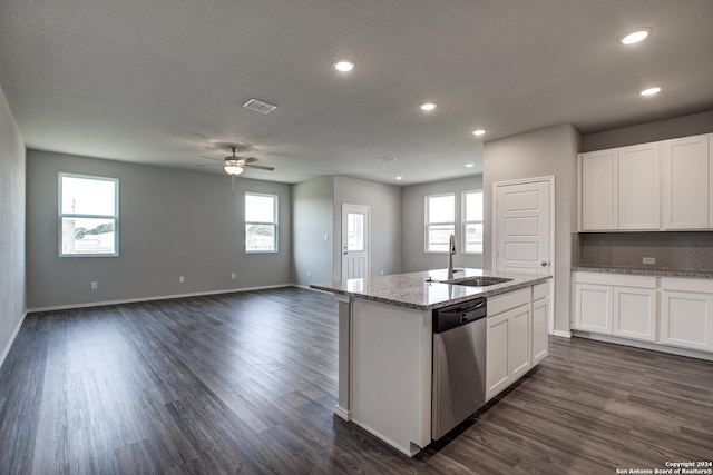 kitchen with dark wood-style floors, visible vents, stainless steel dishwasher, white cabinets, and a sink