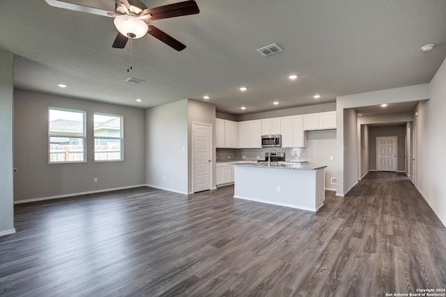 kitchen with visible vents, stainless steel microwave, and open floor plan