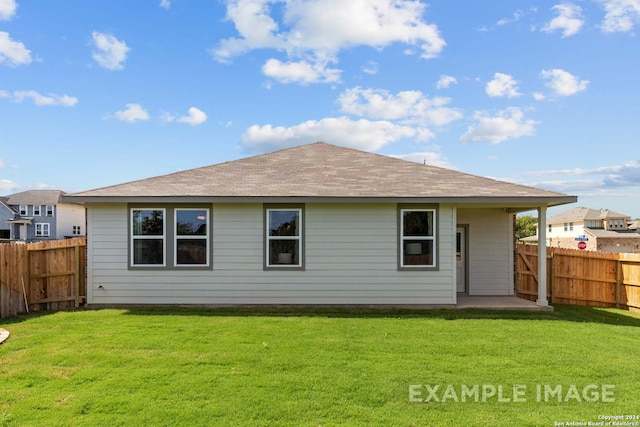 rear view of house featuring a fenced backyard and a yard