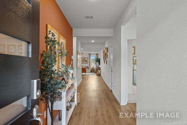 hallway with wood finished floors and visible vents