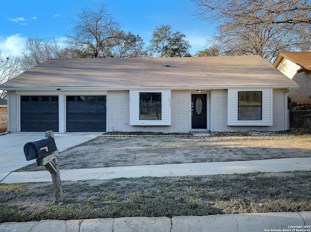 view of front of house featuring a garage, brick siding, and driveway