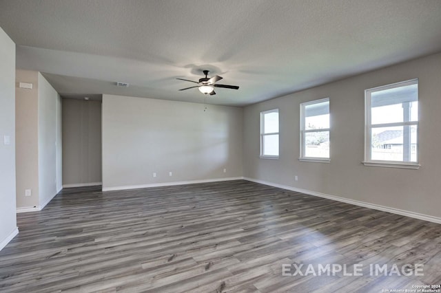 unfurnished room with a textured ceiling, ceiling fan, visible vents, baseboards, and dark wood finished floors