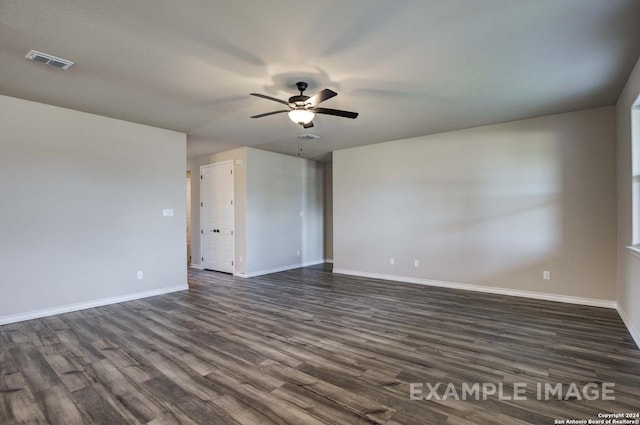 unfurnished room featuring ceiling fan, dark wood finished floors, visible vents, and baseboards