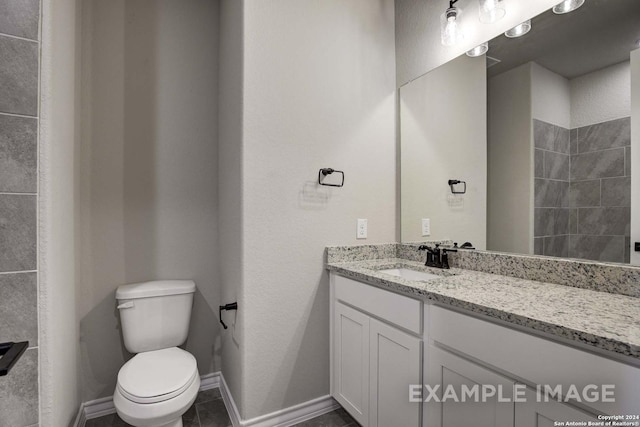 bathroom featuring vanity, toilet, and baseboards