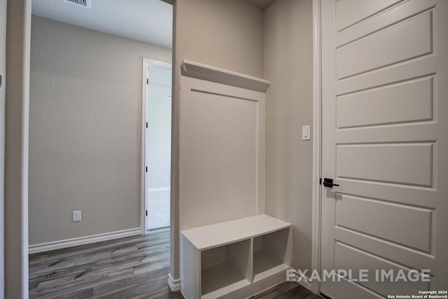 mudroom with dark wood finished floors and baseboards