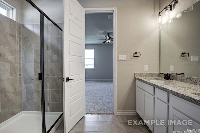 bathroom with double vanity, a stall shower, and a ceiling fan