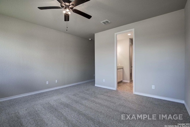 unfurnished bedroom with connected bathroom, light carpet, a ceiling fan, visible vents, and baseboards